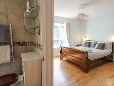 a bedroom with a bed and a window at The Coach House at Plas Dolguog in Machynlleth