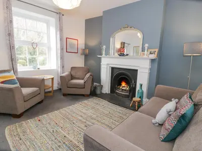 a living room with a couch and a fireplace at Swn Yr Afon in Tywyn