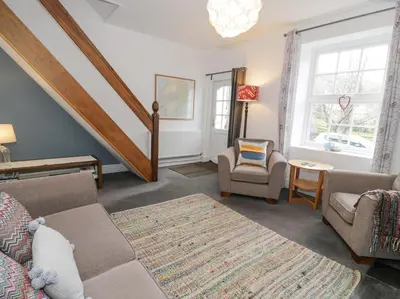 a living room with a couch and a chair at Swn Yr Afon in Tywyn