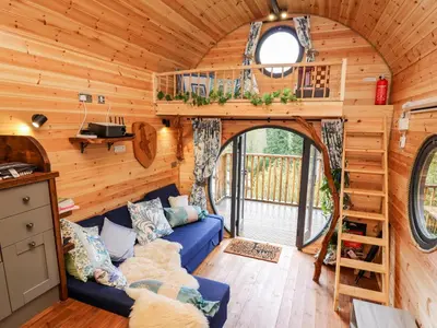 a living room with a blue couch in a tiny house at The Kites Nest in Ystrad Meurig