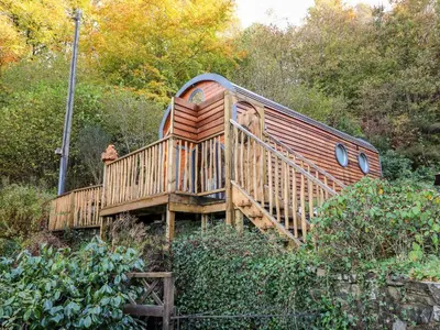 a wooden train house sitting on a wooden bridge at The Kites Nest in Ystrad Meurig