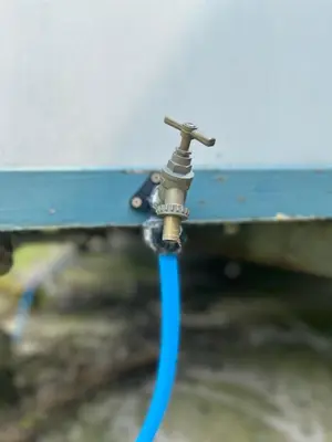 a water hose hooked up to a blue bench at Ox Box Cabin Lyonshall Kington in Hereford