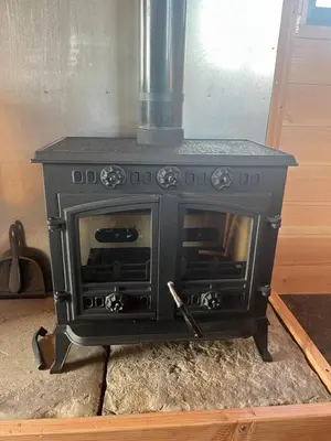a black stove is sitting in a room at Ox Box Cabin Lyonshall Kington in Hereford