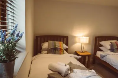 a bedroom with two beds with towels and a lamp at The Clockhouse in Montgomery