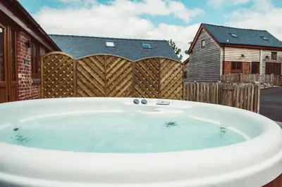 a hot tub in a backyard with a wooden fence at The Clockhouse in Montgomery