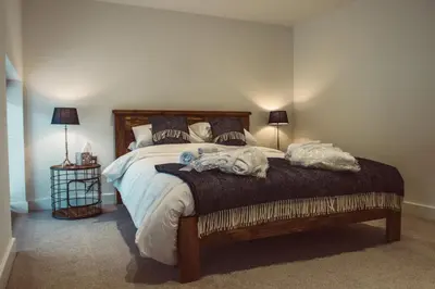 a bedroom with a large bed with towels on it at The Clockhouse in Montgomery