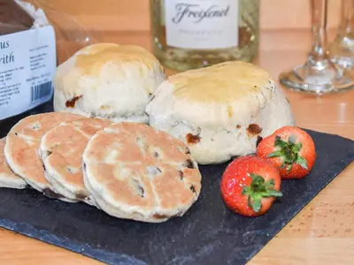 a group of buns and strawberries on a plate at Cartws Blaenparc Coach House - Uk41031 in Mydroilin