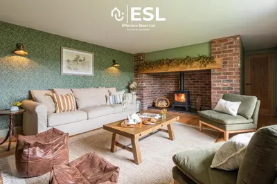 a living room with a couch and a fireplace at Large Country Farmhouse, Shropshire Hills View, with Hot Tub in Minsterley