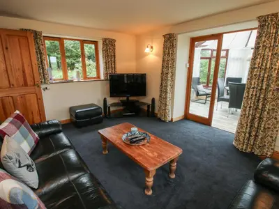 a living room with a leather couch and a coffee table at Rowan Cottage in Shrewsbury