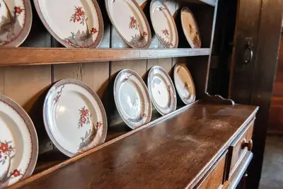 a collection of plates in a wooden cabinet at Penuwch Fach in Aberystwyth