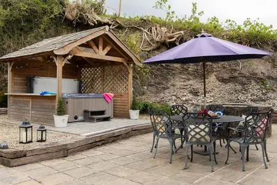 a table and chairs with an umbrella on a patio at Penuwch Fach in Aberystwyth