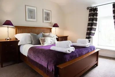a bedroom with a bed with towels on it at Penuwch Fach in Aberystwyth
