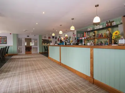 a bar in the middle of a room with a bar counter at Mallard in Leominster