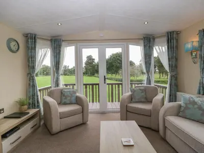 a living room with a couch and chairs and a balcony at Mallard in Leominster