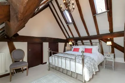 an attic bedroom with a bed and a chair at 12A College Hill by Sleep Shrewsbury in Shrewsbury