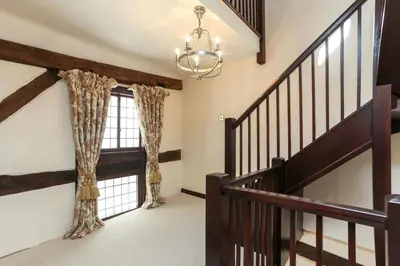 a home with a staircase and a chandelier at 12A College Hill by Sleep Shrewsbury in Shrewsbury