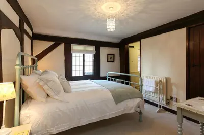 a bedroom with a white bed with a wooden frame at 12A College Hill by Sleep Shrewsbury in Shrewsbury