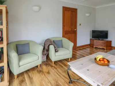 a living room with two chairs and a coffee table at Rhydygroes in Lampeter