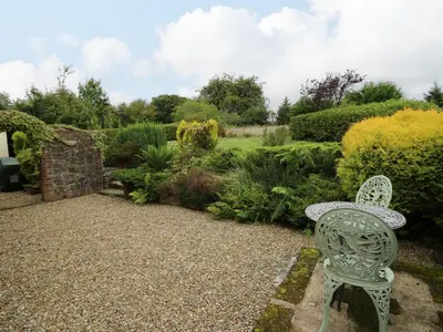 a white chair sitting in the middle of a garden at Rhydygroes in Lampeter