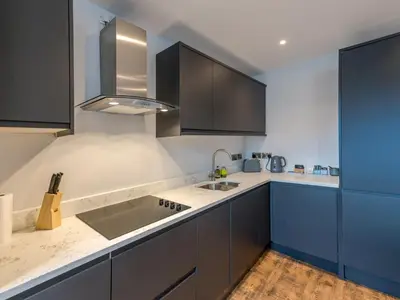 a kitchen with blue cabinets and a sink at 5A One Bedroom Modern Town Centre Apartment - Pass the Keys in Shrewsbury