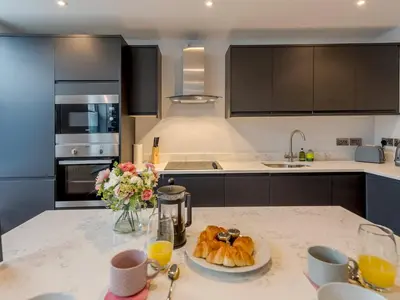 a kitchen with a table with a plate of croissants at 5A One Bedroom Modern Town Centre Apartment - Pass the Keys in Shrewsbury