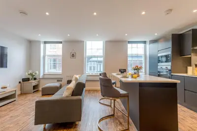 a kitchen and living room with a couch and a table at 5B One bedrom Central Modern Apartment - Pass the Keys in Shrewsbury