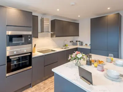 a kitchen with gray cabinets and a white counter top at 5B One bedrom Central Modern Apartment - Pass the Keys in Shrewsbury