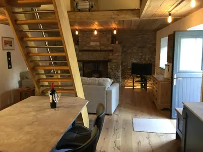 a living room with a table with a wine bottle on it at No 1 Dolheulog Aberaeron SA46 0EP in Aberaeron
