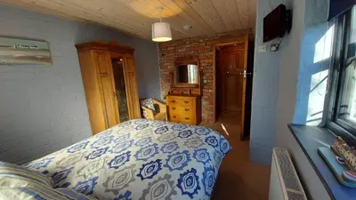 a bedroom with a blue and white bed in a room at No 1 Dolheulog Aberaeron SA46 0EP in Aberaeron