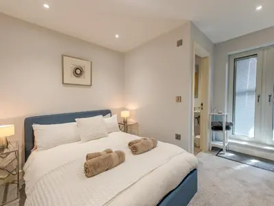 a bedroom with a large white bed with towels on it at 40C 2 bed Celosia Beautiful Town Centre Apartment - Pass the Keys in Shrewsbury