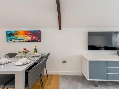 a dining room with a white table and chairs at 40C 2 bed Celosia Beautiful Town Centre Apartment - Pass the Keys in Shrewsbury