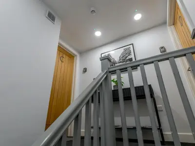 a staircase in a home with white walls and a wooden door at 40C 2 bed Celosia Beautiful Town Centre Apartment - Pass the Keys in Shrewsbury