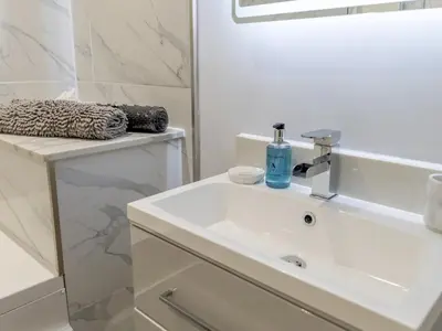 a white bathroom with a sink and a mirror at 1 bed 40C Beautiful Town Apartment Celosia - Pass the Keys in Shrewsbury