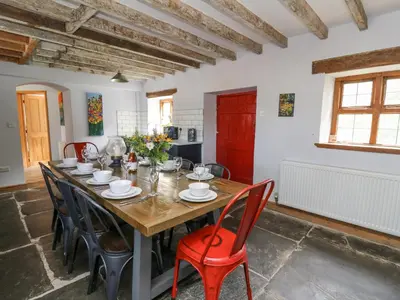 a dining room with a wooden table and chairs at Nanthir House in Llandrindod Wells