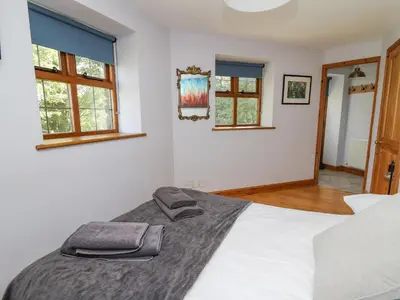 a bedroom with a white bed with two towels on it at Nanthir House in Llandrindod Wells