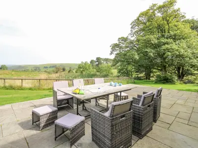a patio with a table and chairs on a patio at Nanthir House in Llandrindod Wells