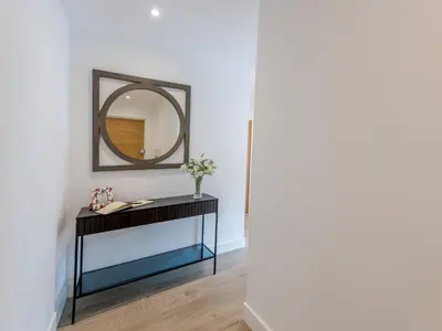 a mirror on a wall next to a black console table at Contemporary Apartment with Secure Parking - Pass the Keys in Shrewsbury