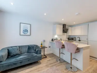 a living room with a couch and a kitchen at Amaranth Stylish town centre apartment - Pass the Keys in Shrewsbury