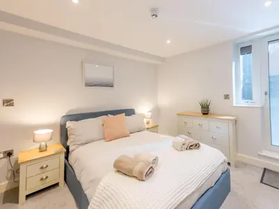 a bedroom with a bed and two windows at Amaranth Stylish town centre apartment - Pass the Keys in Shrewsbury