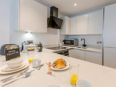 a kitchen with a table with a plate of food on a counter at Amaranth Stylish town centre apartment - Pass the Keys in Shrewsbury