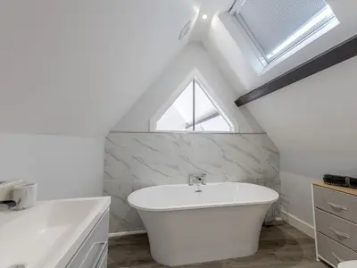 a bathroom with a white bath tub and a window at Dahlia Contemporary town centre apartment - Pass the Keys in Shrewsbury