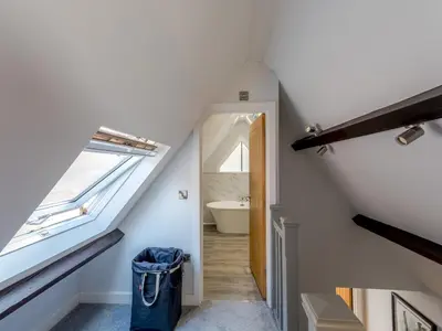 a bathroom with a staircase with a sink and a tub at Dahlia Contemporary town centre apartment - Pass the Keys in Shrewsbury