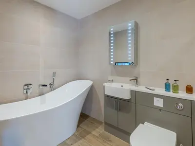 a bathroom with a tub and a toilet and a sink at 1 bed Albury Contemporary Apartment with Secure Parking - Pass the Keys in Shrewsbury