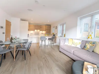 a living room and kitchen with a couch and a table at 1 bed Albury Contemporary Apartment with Secure Parking - Pass the Keys in Shrewsbury