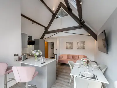 a living room with a white table and pink couch at 1 bed 40D Dahlia Contemporary town centre apartment - Pass the Keys in Shrewsbury