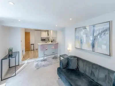 a living room with a couch and a large painting on the wall at Bouvardia Modern town centre apartment - Pass the Keys in Shrewsbury