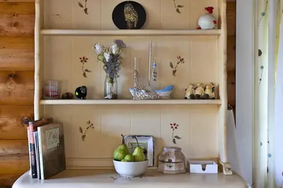 a shelf with a bowl of pears and a vase of flowers at Finest Retreats - Mountain View in Trawsfynydd