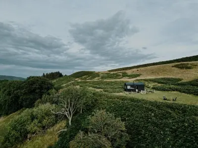 a view of a field with a house on a hill at Hoku in Llangollen