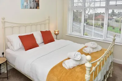a bedroom with a white bed with towels on it at Cosy yet spacious, 3BR, Parking, Village Location in Oswestry