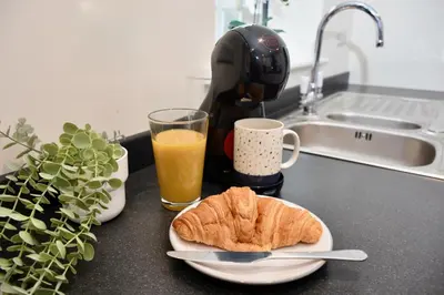 a table with a plate of food and a glass of orange juice at Cosy yet spacious, 3BR, Parking, Village Location in Oswestry